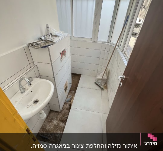 חדר אמבטיה עם כיור וצנרת חשופה